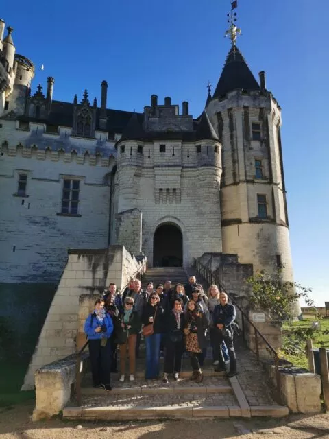 Groupe de photographes posant dans les escaliers montant au château de Saumur, en arrière-plan